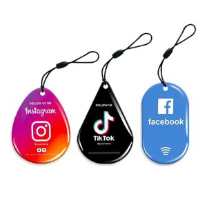 Three teardrop social media NFC epoxy tags with Instagram, TikTok and Facebook designs on phone lanyards